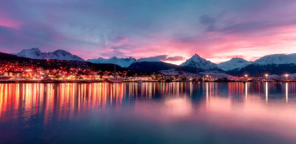 city lights reflecting on water with andes in background  argentina Ushuaia