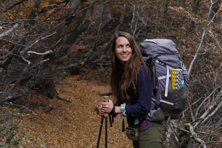 trekking poles benefits solo female hiker with backpack camping gear in forest