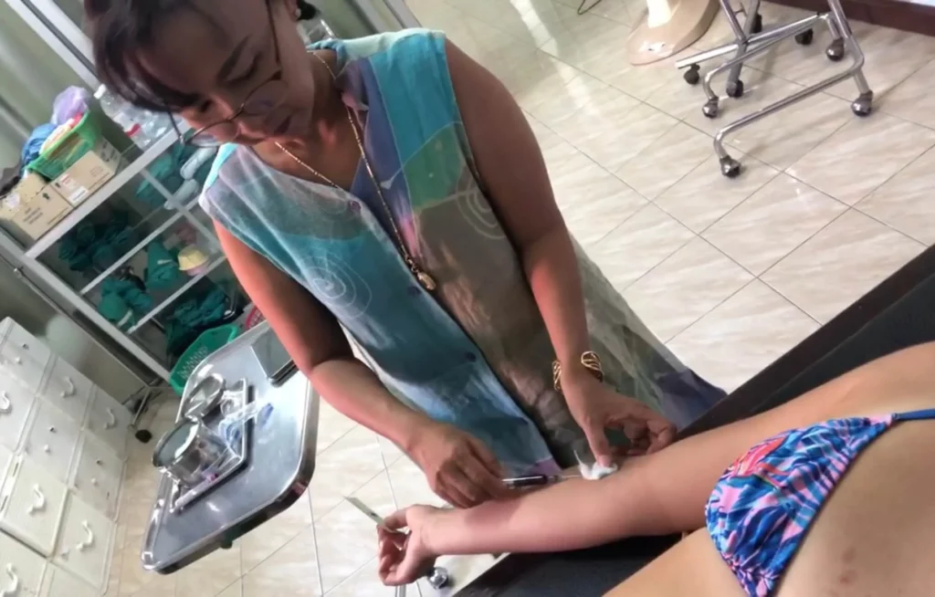woman getting blood drawn by nurse in thailand