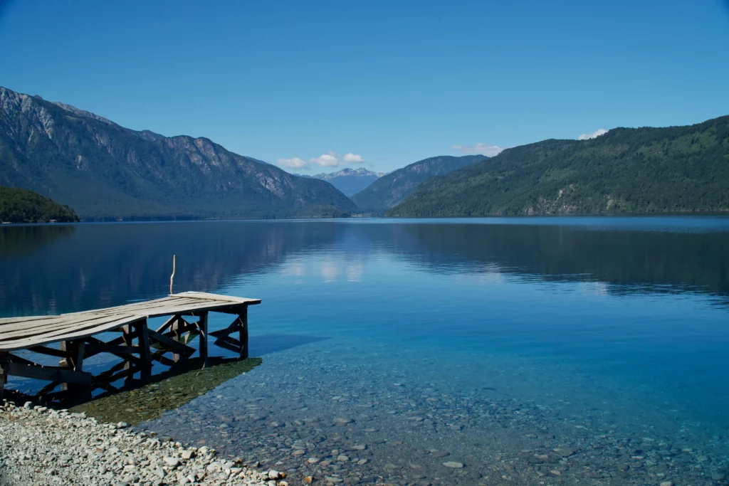 wooden dock on blue lake surrounded by mountains lakes district best places to visit in chile