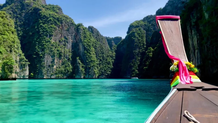 traditional thai longtail boat in the turquoise waters of pileh lagoon surrounded by limestone cliffs