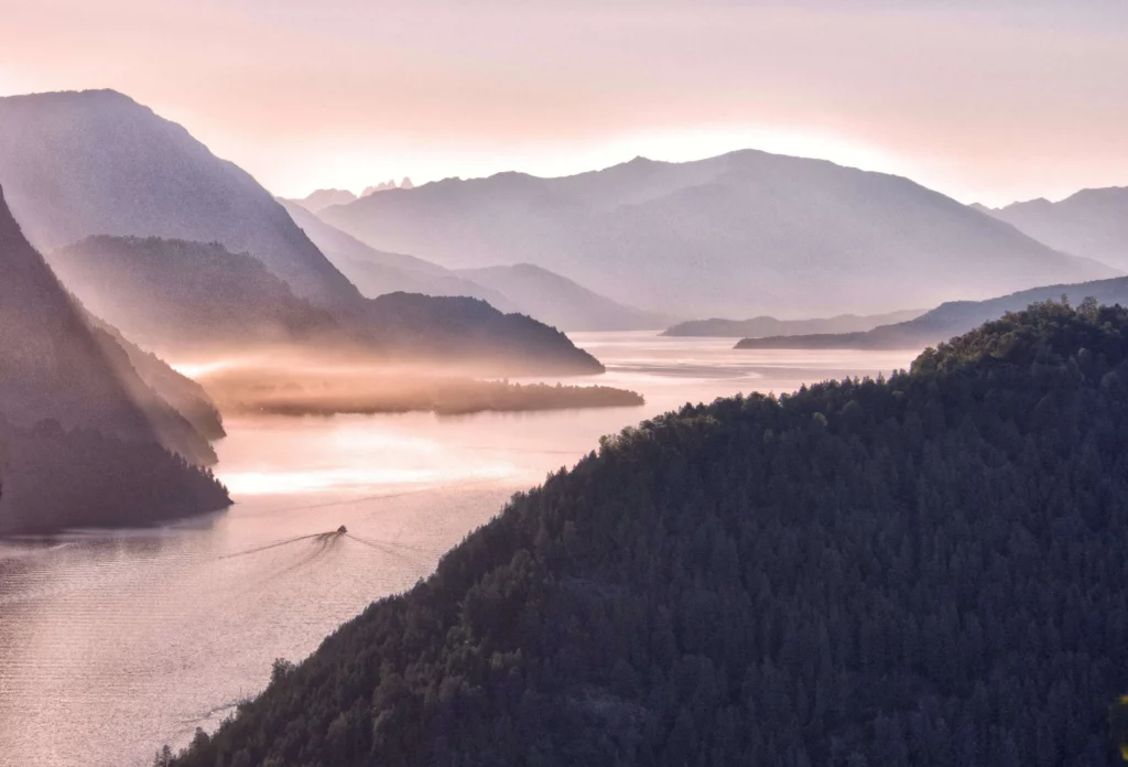 sunlight shines through mountains onto lake in San Martín de los Andes argentina