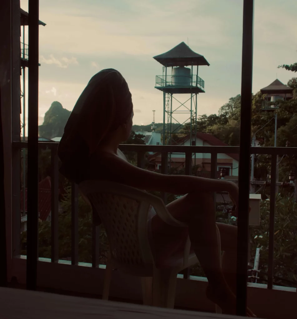 solo traveler sitting on balcony water tower thailand benefits of solo travel